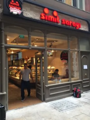 Stone-fronted Simit Sarayı store with arched openings and a window list of cities